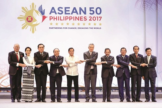 Association of Southeast Asian Nations leaders link arms during the opening ceremony of the 30th Asean Summit in Manila yesterday.