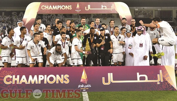 CUP OF JOY: Al Saddu2019s captain Xavi Hernandez makes a dramatic  leap to join Hassan al-Haydos and other Al Sadd players as they celebrate with the Qatar Cup trophy yesterday.