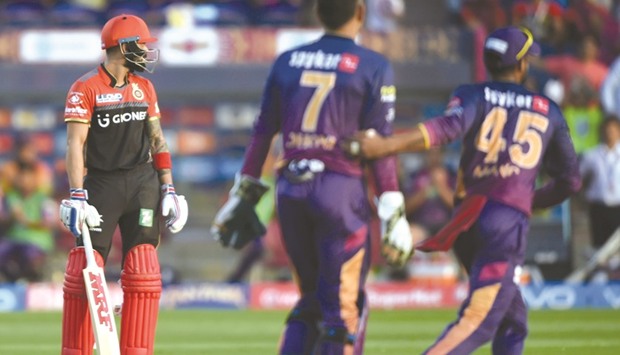 RCB captain Virat Kohli (left) looks on as RPS cricketers Mahendra Singh Dhoni (centre) and teammate Manoj Tiwary celebrate the dismissal of RCBu2019s Kedar Jadhav during the IPL match in Pune yesterday. (AFP)