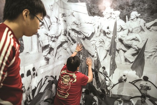 Workers install a poster at the June 4th museum in Hong Kong yesterday.