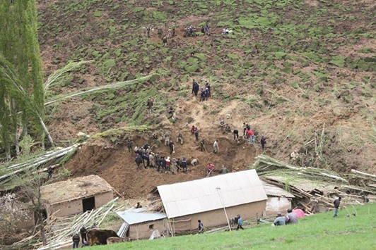 A handout picture taken yesterday and provided by the Kyrgyz Red Crescent Society press service shows rescue workers and soldiers working at the site of a landslide in the village of Ayu in Kyrgyzstanu2019s Osh region.