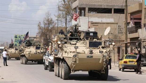 US military vehicles travel in the northeastern city of Qamishli, Syria on Saturday.