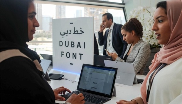 Attendees look at computers showing the ,Dubai Font,, the first typeface developed by Microsoft for Dubai