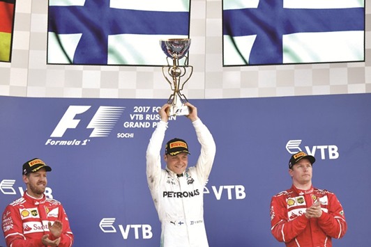 Winner Mercedesu2019 Finnish driver Valtteri Bottas (C) celebrates on the podium with second placed Ferrariu2019s German driver Sebastian Vettel (L) and third placed Ferrariu2019s Finnish driver Kimi Raikkonen (R) after the Formula One Russian Grand Prix yesterday.