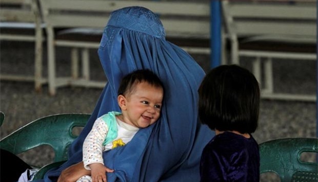 An Afghan refugee woman waits with her children to be repatriated to Afghanistan, at the UNHCR office on the outskirts of Peshawar on Monday.