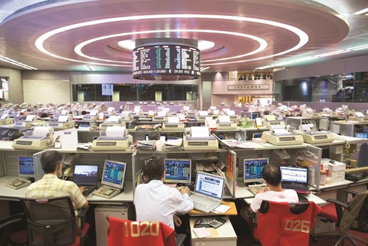 Traders work at the Hong Kong Stock Exchange. The Hang Seng closed up 0.6% to 24,261.48 points yesterday.