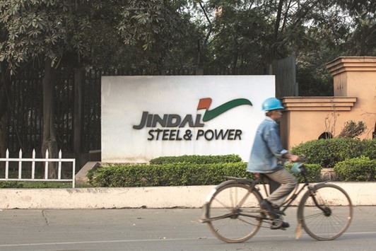 A worker cycles past signage for Jindal Steel & Poweru2019s plant in Chhattisgarh, India. After dropping six straight years on weak sales and high debt, a remarkable turnaround in fortunes has made Jindal Steel the best performer this year among Indiau2019s top 200 stocks.