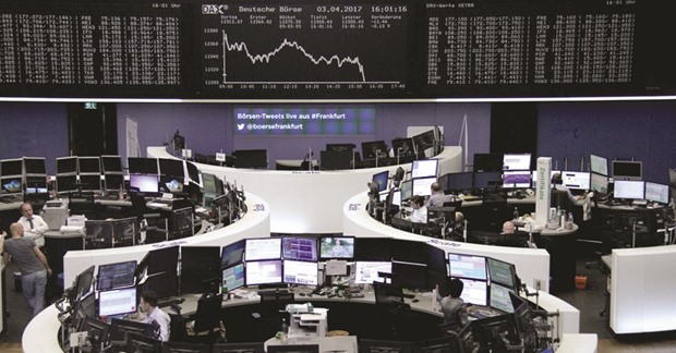 Traders work at the Frankfurt Stock Exchange. The DAX 30 closed down 0.5% to 12,257.20 points yesterday.
