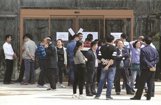 Investors from Chinese cities and local residents stand outside a closed sales office of a property with a seal as the government banned new property sales in counties earmarked as part of a new special economic zone in Xiongxian county, Hebei province, China.