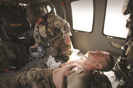 This file photo taken on March 25, 2011 shows a US army flight medic Sergeant Bobby Dorris from Company C, 1st Battalion, 52nd Aviation Regiment, MEDEVAC team treating a US Army soldier (bottom) for an unspecified complaint on their Blackhawk helicopter in southern Afghanistan.