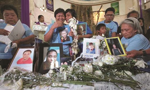Families of drug suspects killed during police anti-drug operations grieve at the Santo Nino Parish Church in Caloocan City.
