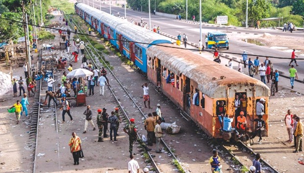 Congolese walk near a train in Kinshasa during a general strike yesterday, called by the opposition.