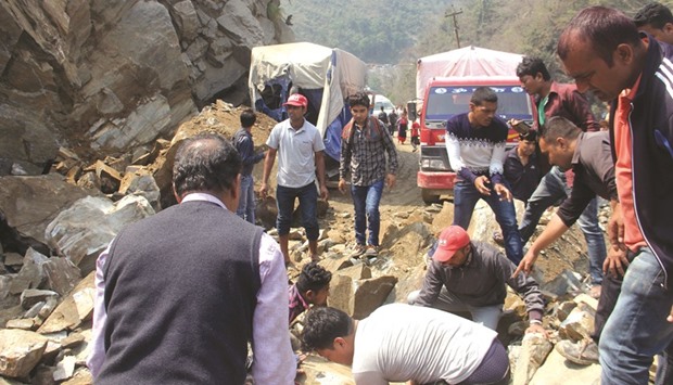 Bystanders try to clear a road after a fatal landslide in Chitwan district, some 97km from Kathmandu yesterday.