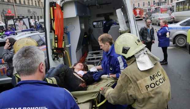An injured person is helped by emergency services outside Sennaya Ploshchad metro station, following explosions in two train carriages at metro stations in St. Petersburg, Russia April 3, 2017.