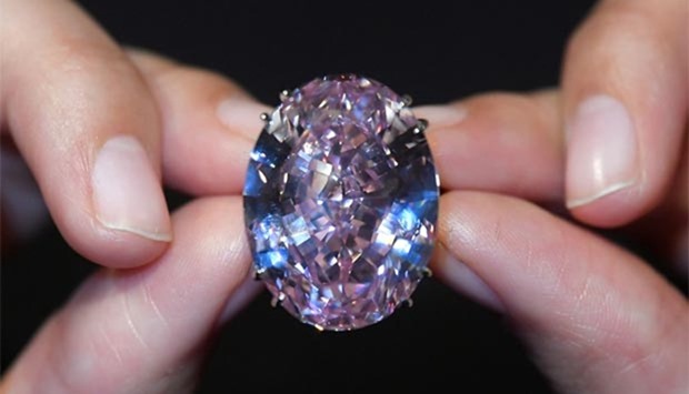 A model poses with a 59.60-carat mixed cut diamond known as ,Pink Star,.