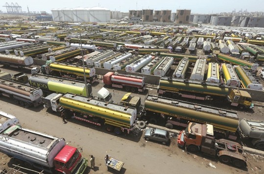 A fruit cart move past oil tankers, parked during a countrywide strike by the Oil Tankers Contractors Association (OTCA), against the imposition of sales tax on the transportation of oil, Karachi, Pakistan yesterday.
