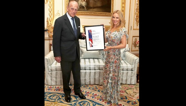 Prince Philip presents singer Kylie Minogue with the Britain-Australia Society Award for 2016 during a private audience in the White Drawing Room at Windsor Castle, in Windsor.