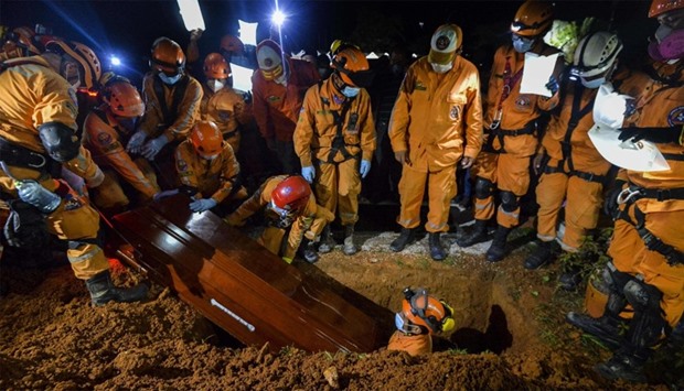 Colombian civil defense workers bury the coffin of Jesus Diago, 33, who died rescuing his family during the mudslide