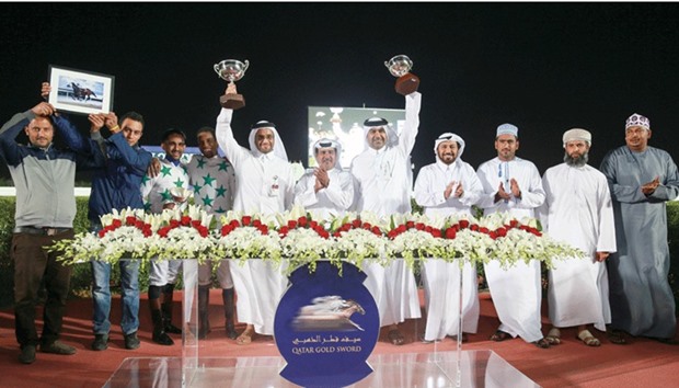 Owner Sheikh Faisal bin Hamad bin Jassim al-Thani and trainer Ibrahim al-Malki lift their trophies after Topsy Turvy won the Mesaimeer Cup yesterday. PICTURE: Juhaim