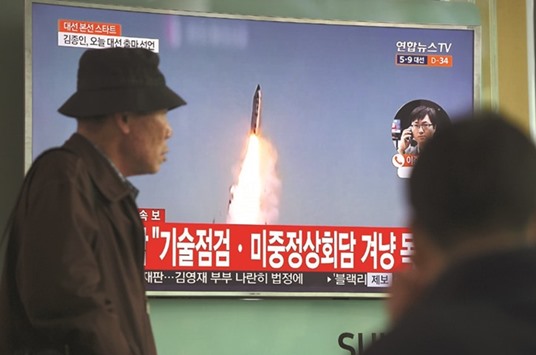 A man walks past a television screen showing file footage of a North Korean missile launch, at a railway station in Seoul yesterday.