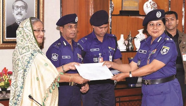 A police official receiving an allotment letter of housing plot from Prime Minister Sheikh Hasina at a function in Dhaka yesterday.