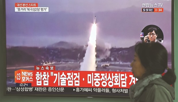 A woman walks past a television screen showing file footage of a North Korean missile launch, at a railway station in Seoul yesterday. Nuclear-armed North Korea fired a ballistic missile into the Sea of Japan yesterday, just ahead of a highly-anticipated China-US summit at which Pyongyangu2019s accelerating atomic weapons programme is set to top the agenda.