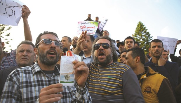 Palestinian employees take part in a protest in Gaza City yesterday against a decision by the West Bank-based Palestinian Authority to impose pay cuts on its civil servants.