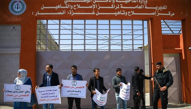 Palestinians demonstrate outside an Interior Ministry building in Gaza City, run by Hamas, as they carry signs condemning u2018collaboratorsu2019 and u2018spiesu2019 working for Israel