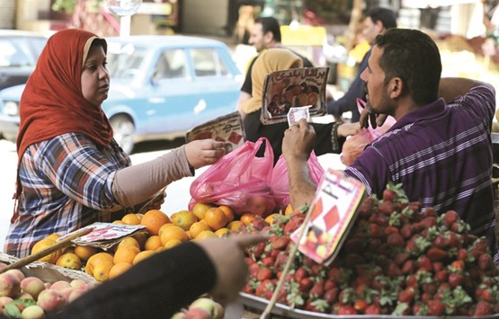 An Egyptian woman shops at a vegetable market in Cairo (file). The flotation of the pound and an accompanying increase in subsidised fuel prices have hammered consumers in the nation of 92mn, about half of whom live near or below the poverty line.