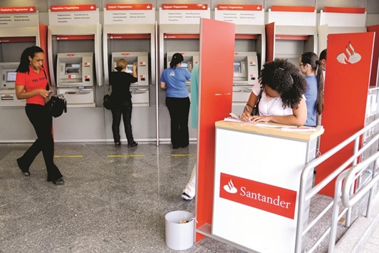Customers use ATMs at a Banco Santander Brasil branch in Sao Paulo (file). The QIA took advantage of an 18-month rally that doubled the price of Santander Brasilu2019s units to cash out after seven years as the second biggest shareholder in the Brazilian unit of Spainu2019s Banco Santander.