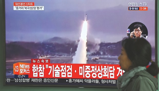 A woman walks past a television screen showing file footage of a North Korean missile launch, at a railway station in Seoul yesterday. Nuclear-armed North Korea fired a ballistic missile into the Sea of Japan yesterday, just ahead of a highly-anticipated China-US summit at which Pyongyangu2019s accelerating atomic weapons programme is set to top the agenda.