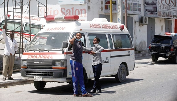 Aamin Ambulance staff wait with their ambulance near the scene of a suicide car explosion in Maka Al Mukarama street of Mogadishu on March 31.