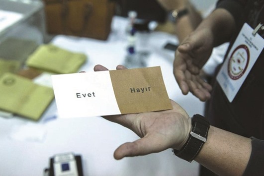 A Turkish voter holds a ballot with a u2018Yesu2019 and a u2018Nou2019, written in Turkish, at a polling station for the Turkish referendum in the northern part of the divided Cypriot capital Nicosia.