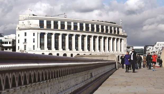 Pedestrians walk across Blackfriars Bridge with the Unilever headquarters standing in the background on Victoria Embankment in London. Losing Unilever would be a blow for UK Prime Minister Theresa May, coming soon after she started divorce proceedings from the European Union.