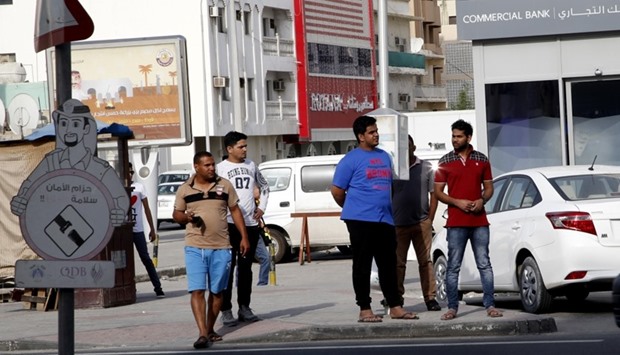 People wait at an 'open air' bus stop in Doha's Najma area. PICTURE: Jayaram Korambil.