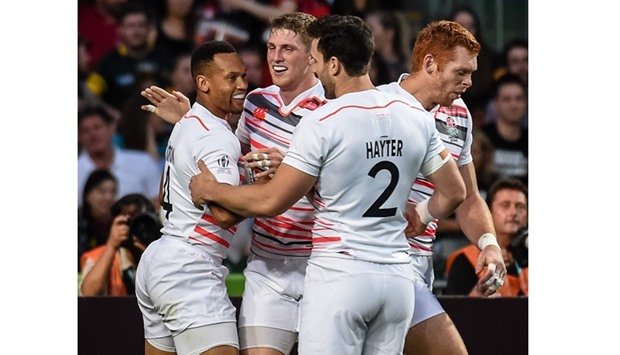 Dan Norton (left) celebrates with his teammates after scoring a try against South Korea at the Rugby Sevens tournament in Hong Kong yesterday. (AFP)