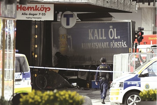 Police officers cordon the truck which crashed into the Ahlens department store at Drottninggatan, in central Stockholm.