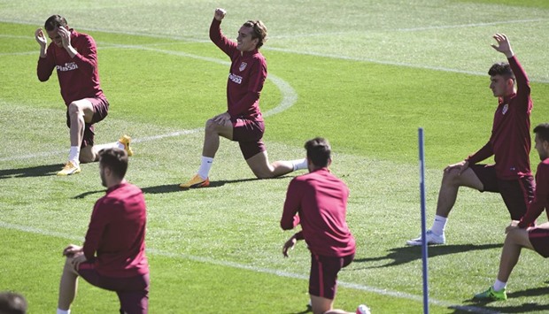 Atletico Madridu2019s French forward Antoine Griezmann (C) and teammates stretch during a training session at Atletico de Madridu2019s sport city in Majadahonda, near Madrid.