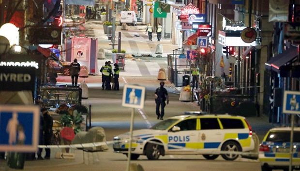 Police work at the scene as night falls after a truck slammed into a crowd of people outside a busy department store in central Stockholm, causing u201cdeathsu201d in what the prime minister described as a u201cterror attacku201d yesterday.
