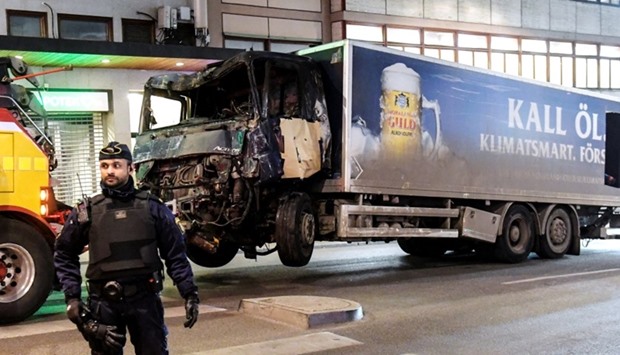 Tow trucks pull away the beer truck that crashed into the department store Ahlens after plowing down the Drottninggatan Street in central Stockholm, Sweden.