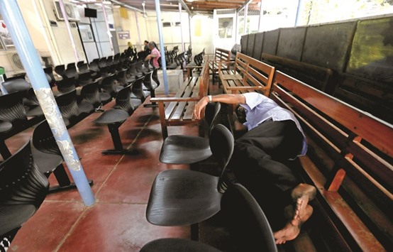 A patient sleeps on a chair at a day clinic while waiting to see a doctor during a doctors strike being held in protest against the government in Colombo.