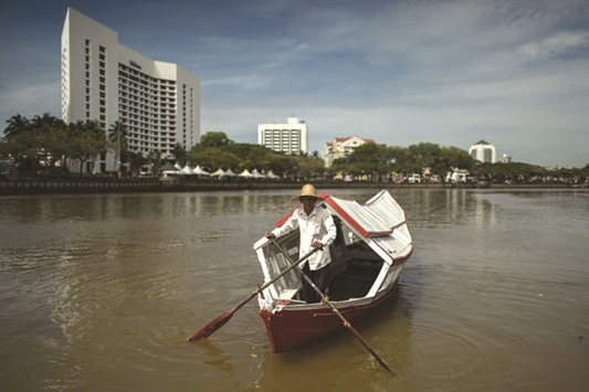 A boatman paddles his water taxi on the Sarawak river in Kuching, capital of the Malaysian state of Sarawak on the island of Borneo.