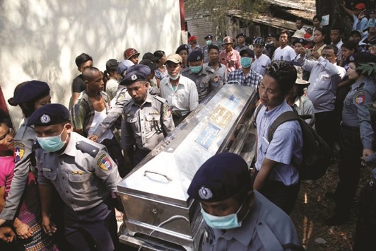 Police carry a victimu2019s body at Pathein General Hospital after a boat with 60 passengers capsized in Pathein river late on Friday.