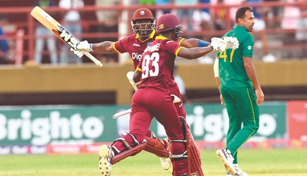 Wahab Riaz (R) of Pakistan walks off the field as Ashley Nurse (L) and Jason Mohammed (C) of West Indies celebrate the victory.