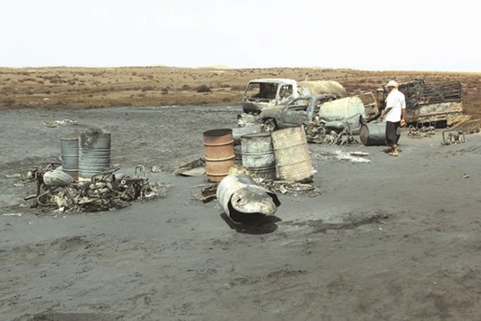 A man walks at the site of a crude oil pipeline explosion and fire near the Red Sea port of Hodeida, Yemen, yesterday.