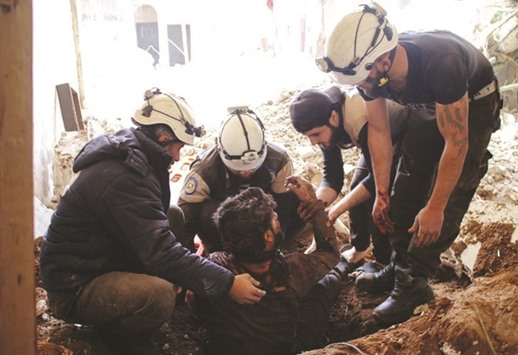 Members of the Syrian civil defence volunteers, also known as the White Helmets, remove a victim from the rubble of his house yesterday, following a reported air strike by government forces on a rebel-held area in Daraa.