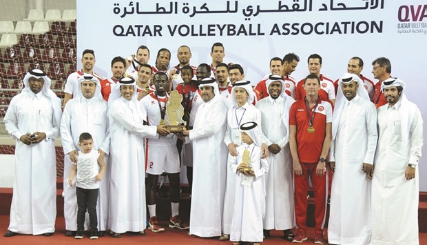 Al Arabi players pose with volleyball officials after winning the Qatar Cup title yesterday.
