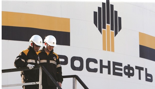 Workers stand next to a logo of Russiau2019s Rosneft oil company at the central processing facility of the Rosneft-owned Priobskoye oil field outside the West Siberian city of Nefteyugansk, Russia (file). The Russian state-run produceru2019s trading arm will buy Kurdish oil from now until 2019, Rosneft said in February.