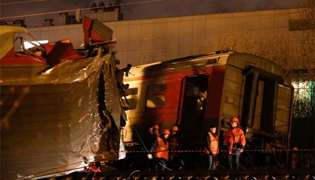 Emergencies Ministry members work at the site of a collision between a passenger train and a suburban train in Moscow on Sunday.