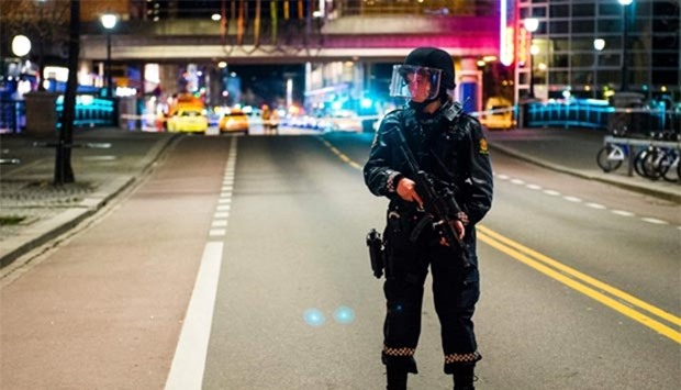 A police officer stands guard near a cordened-off area in central Oslo, after police arrested a man following the discovery of a 'bomb-like device'.